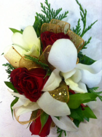 Christmas wrist corsage with red roses, orchids and wintergreens